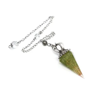 Detail view of peridot resin pendulum with copper wire and crown accent
