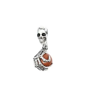 Detailansicht eines Punk-Totenkopf-Anhängers mit Skeletthand und Goldstein-Perle.