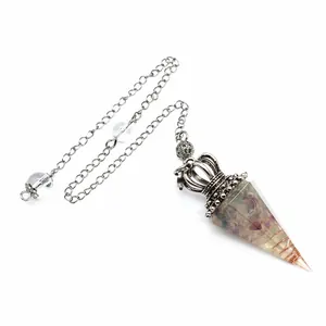 Close-up detail of a crystal crushed stone resin pendulum with ornate silver crown cap