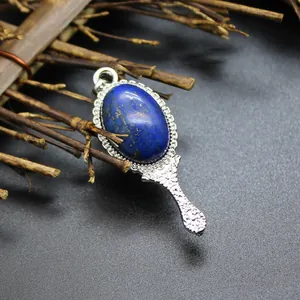 Detailed view of a vintage hand mirror pendant with a blue natural stone inlay.