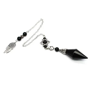 Detail of a black faceted stone pendulum with dreamcatcher and hexagram charms