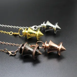 Primo piano di pendoli divinatori in metallo conico in oro, argento e bronzo.