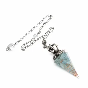 Detailed view of hexagonal resin crystal pendulum with blue crushed stones and copper coil