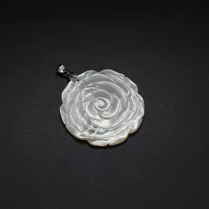 Macro detail of the natural mother-of-pearl rose carving on the pendant