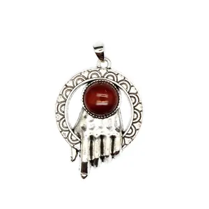 Ciondolo vintage in argento con pietra agata rossa tenuta da una mano nel cerchio