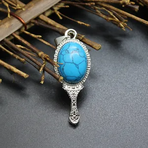 Exquisite detail of a vintage hand mirror pendant featuring a blue turquoise stone.
