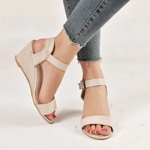 Detailed view of stylish women's beige suede wedge sandals with adjustable ankle strap