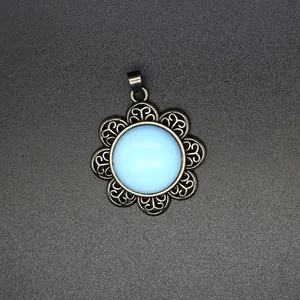 Detail view of an antique silver flower pendant featuring a round light blue natural stone.