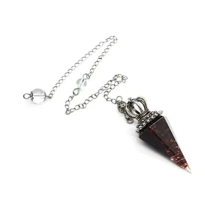 Macro detail of a dark red crystal resin pendulum featuring a silver crown cap and chain