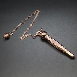 Detalle del péndulo de adivinación hexagonal en metal oro rosa con cadena y cuenta.