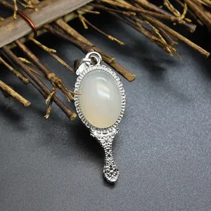 Detailed macro shot of a vintage silver magic mirror pendant with natural white stone.