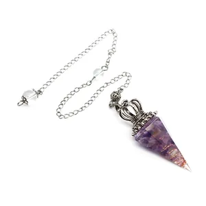 Detail view of amethyst crystal resin pendulum with ornate silver crown and copper coil