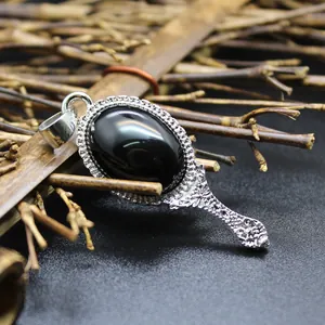 Detailed view of a vintage silver magic mirror pendant with a black stone inlay.