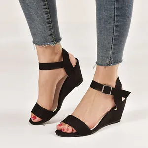 Close-up view of black women's wedge sandals featuring an adjustable ankle buckle strap.