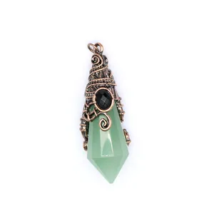 Detailed macro view of green crystal hexagonal point pendant with antique copper wire wrap