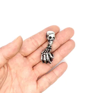 Detailansicht des Punk-Skeletthand-Anhängers mit einer dunklen Natursteinkugel.