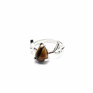 Macro view of teardrop-shaped tiger eye ring featuring elegant silver antler design accents