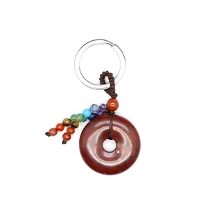Detail van een natuurlijke rode stenen sleutelhanger met zeven gekleurde chakra-kralen