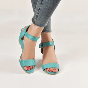 Macro view of turquoise wedge sandals with ankle strap and metal buckle detail