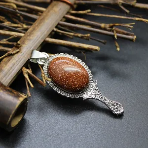 Detail view of a vintage mirror-shaped pendant with a sparkling goldstone.