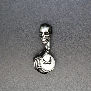 Detailansicht eines silbernen Totenkopf-Anhängers im Punk-Stil mit weißem Naturstein