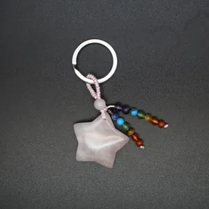 Detail view of rose quartz star keychain with colorful chakra beads and silver ring.