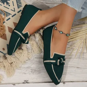 Detalle de los elegantes mocasines de punto verde oscuro con lazo y ribete blanco
