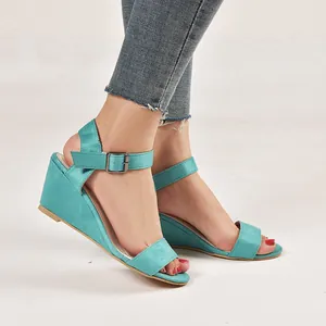 Side view detail of turquoise suede wedge sandals with ankle strap buckle