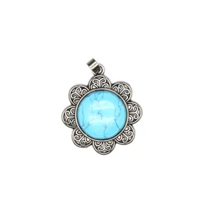 Detail view of a vintage antique silver flower pendant with turquoise stone inlay