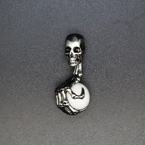 Nahaufnahme eines gotischen Totenkopf-Anhängers mit Skeletthand und weißem Naturstein