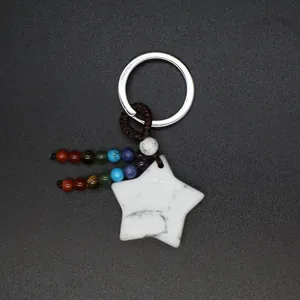 Close-up detail of a white star stone keychain featuring colorful chakra bead tassels