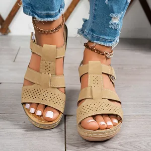 Vista dettagliata di sandali con zeppa beige da donna con motivi traforati al laser.