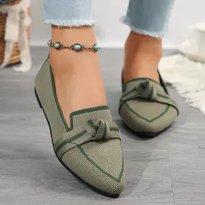 Primer plano de elegantes bailarinas de punto verde en punta con detalle de lazo decorativo