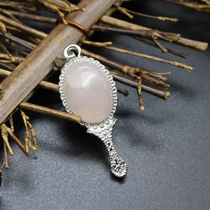 Detail view of a vintage magic mirror pendant with natural pink agate and silver accents