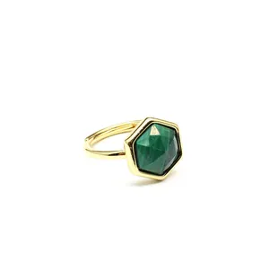 Detailed macro shot of a gold hexagonal ring with a faceted green natural malachite stone.
