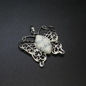 Vista macro dettagliata di un ciondolo a farfalla in argento con pietra naturale di howlite.