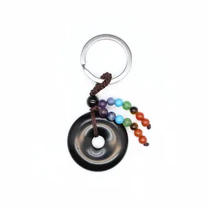Sleutelhanger van zwarte obsidiaan met zeven chakra-kralen en gevlochten koord detail