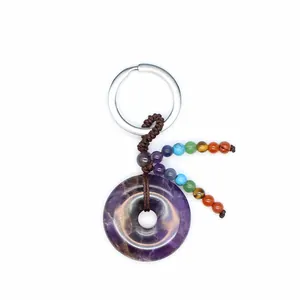 Detailopname van amethist donut sleutelhanger met zeven chakra genezende edelstenen.