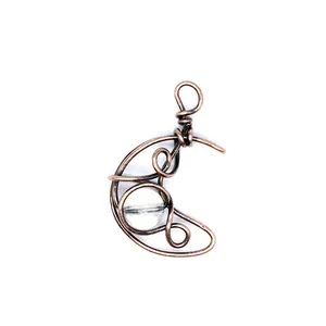 Detailed close-up of handmade copper wire wrapped crescent moon pendant with natural stone
