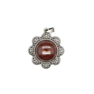 Detailed view of an antique silver flower pendant with a brown natural stone