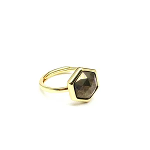 Macro view of a polished gold hexagonal ring with a faceted natural sunstone inlay