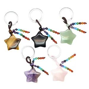 Five natural star-shaped gemstone keychains featuring colorful chakra bead tassels on white background