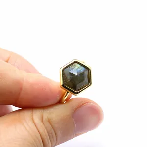 Detailed view of an adjustable gold ring with a hexagonal-cut natural grey sunstone crystal.