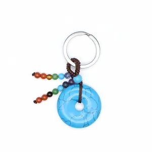 Detailweergave chakra kralen en turquoise donutsteen sleutelhanger met gevlochten koord