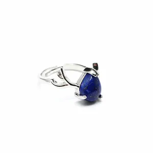 Elegant detail of silver antler ring with a vibrant blue teardrop stone on white background