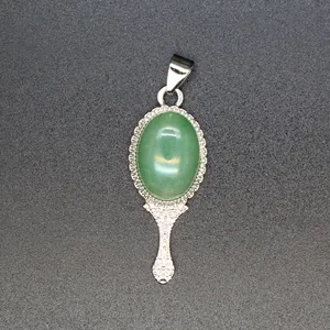 Detail of vintage style hand mirror pendant with green natural stone and ornate engraving