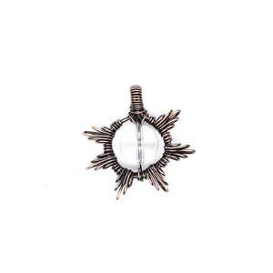 Macro detail showing handmade wire-wrapped copper sun pendant with natural sunstone gem