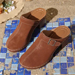 Detail view of stylish brown block heel clogs featuring white stitching and buckle