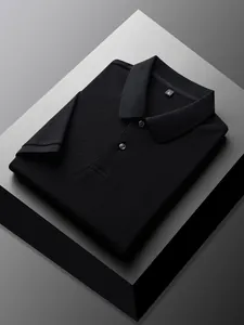 Premium folded black 100% cotton polo shirt displayed on a minimalist geometric pedestal
