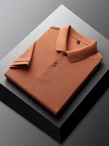 Macro view of a folded burnt orange polo shirt showing pique knit texture and collar detail